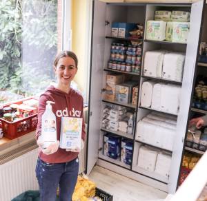 In der Tafel: Ralitsa Anastasova, ehrenamtliche Helferin in der „Recklinghäuser Tafel“, steht vor dem Schrank mit dem neuen Angebot für junge Familien. Foto: SkF Recklinghausen